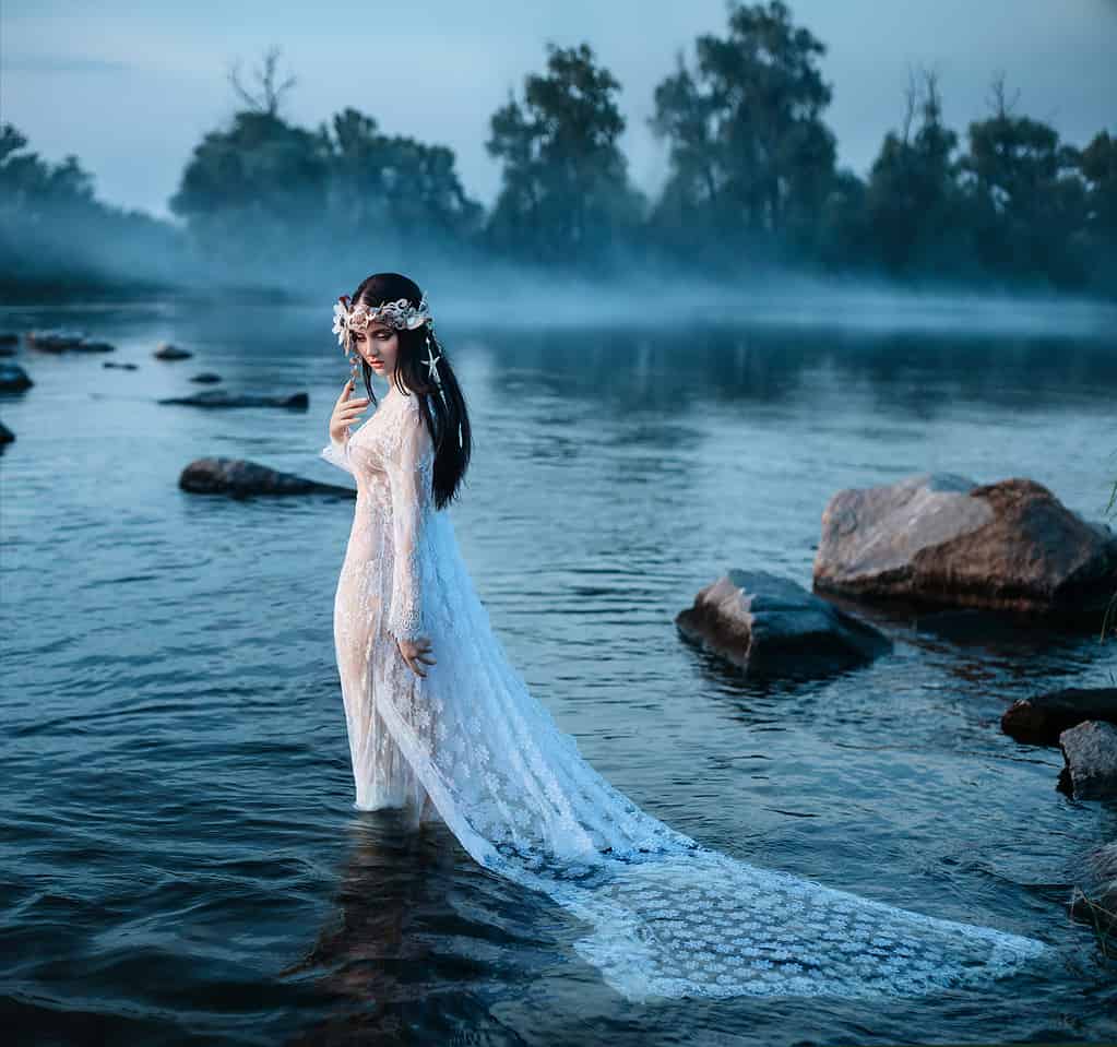 Luxurious lady, in elegant long dress in middle of lake