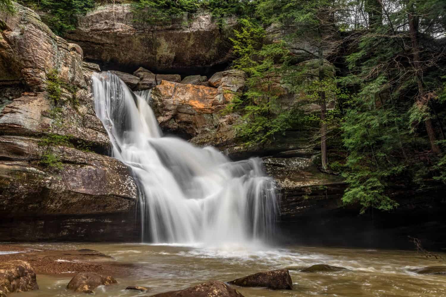Cedar falls, a beautiful waterfall in the Hocking Hills of Ohio, flows strongly after heavy spring rains.