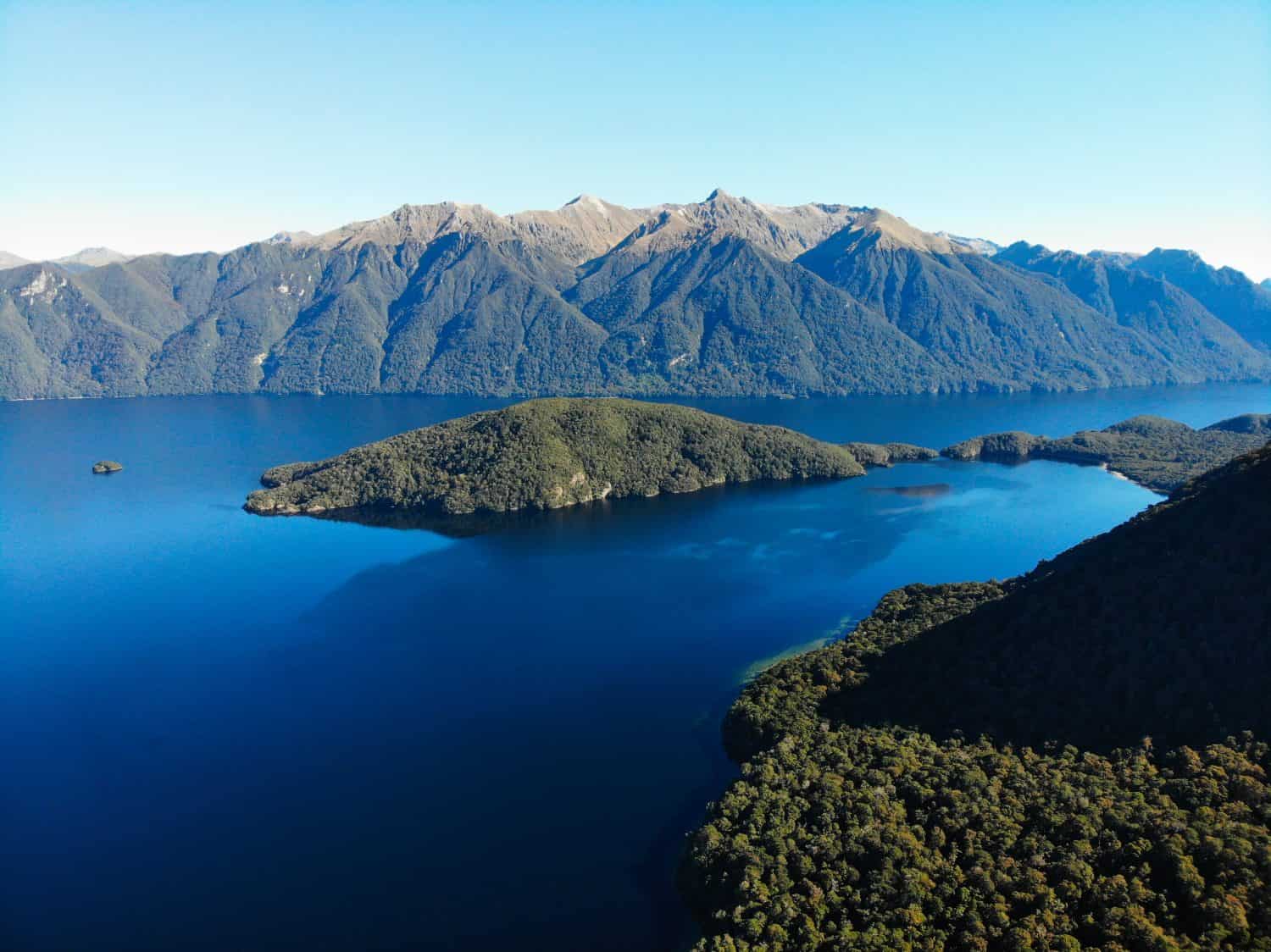 Stunning, dark blue lake between mountains. Lake Hauruko, Fiordland national park, South island, New Zealand. Beautiful, sunny day.