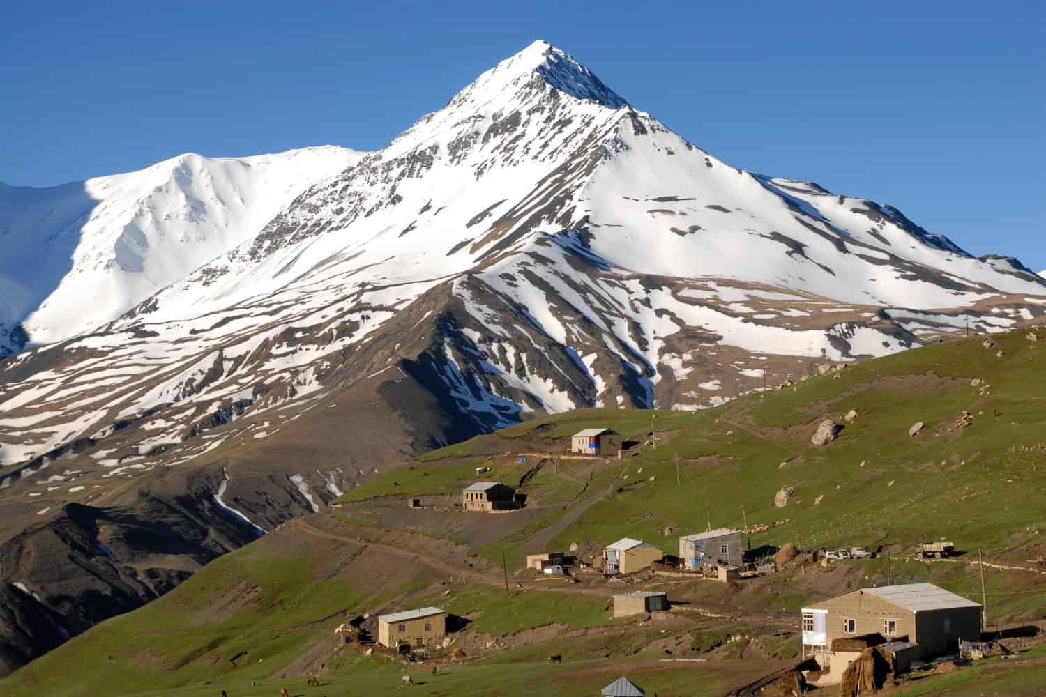 Kurush village (the southernmost point of Russia and the highest mountain settlement in Europe, 2560 m) and Mount Bazarduzu (4,467 m, the highest peak in Azerbaijan). Dagestan, North Caucasus, Russia.