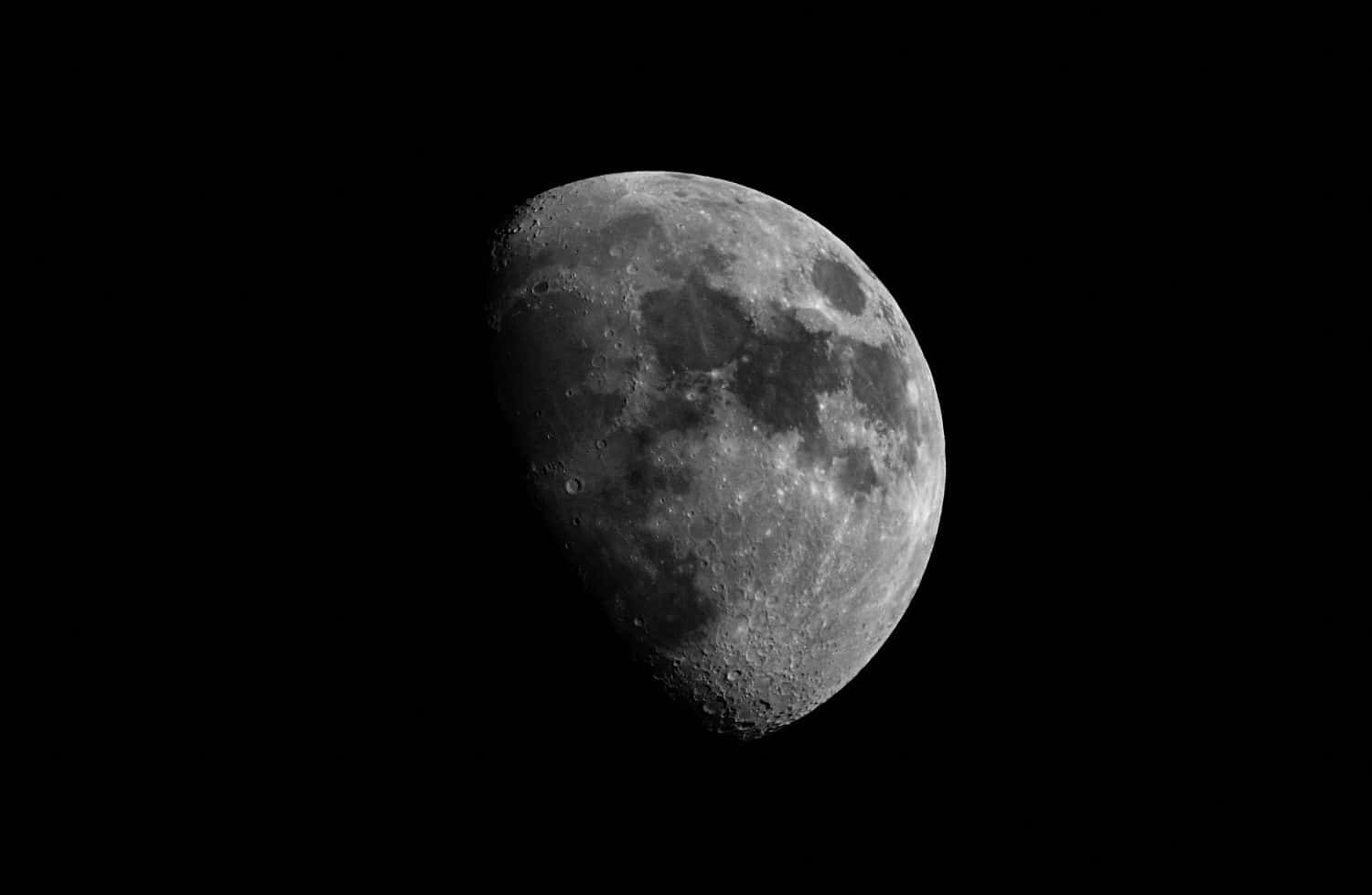 Close-up moon in waxing gibbous phase. Moon surface, craters and the night sky. Isolated on a black background and copy space.