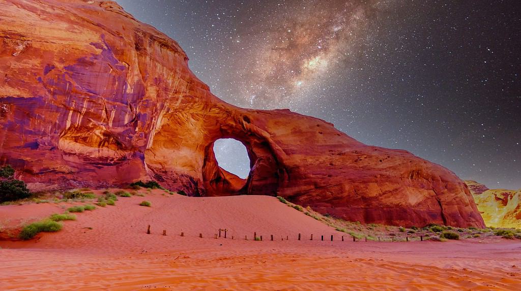 Starry Sky behind the Ear of The Wind, a hole in a rock formation in Monument Valley Navajo Tribal Park on the border of Utah and Arizona, United States
