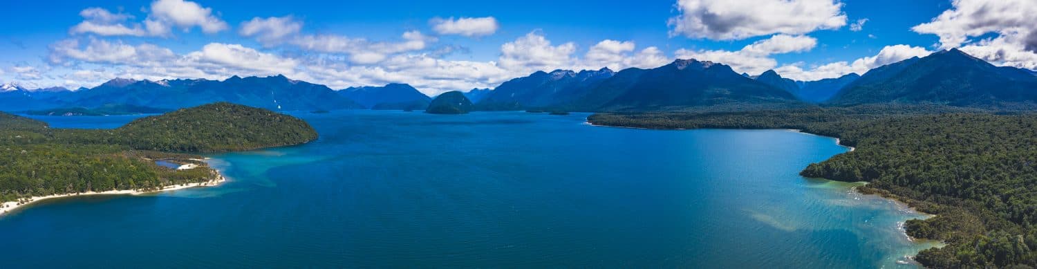 Lake Manapouri in Fiordland National Park Ultra wide panorama of mountain and lake landscape on a sunny day near Te Anau in Southland New Zealand