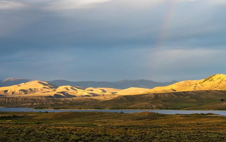 Stormy sky with sun highlighted hills and mountains by Wolford Mountain Reservoir Colorado