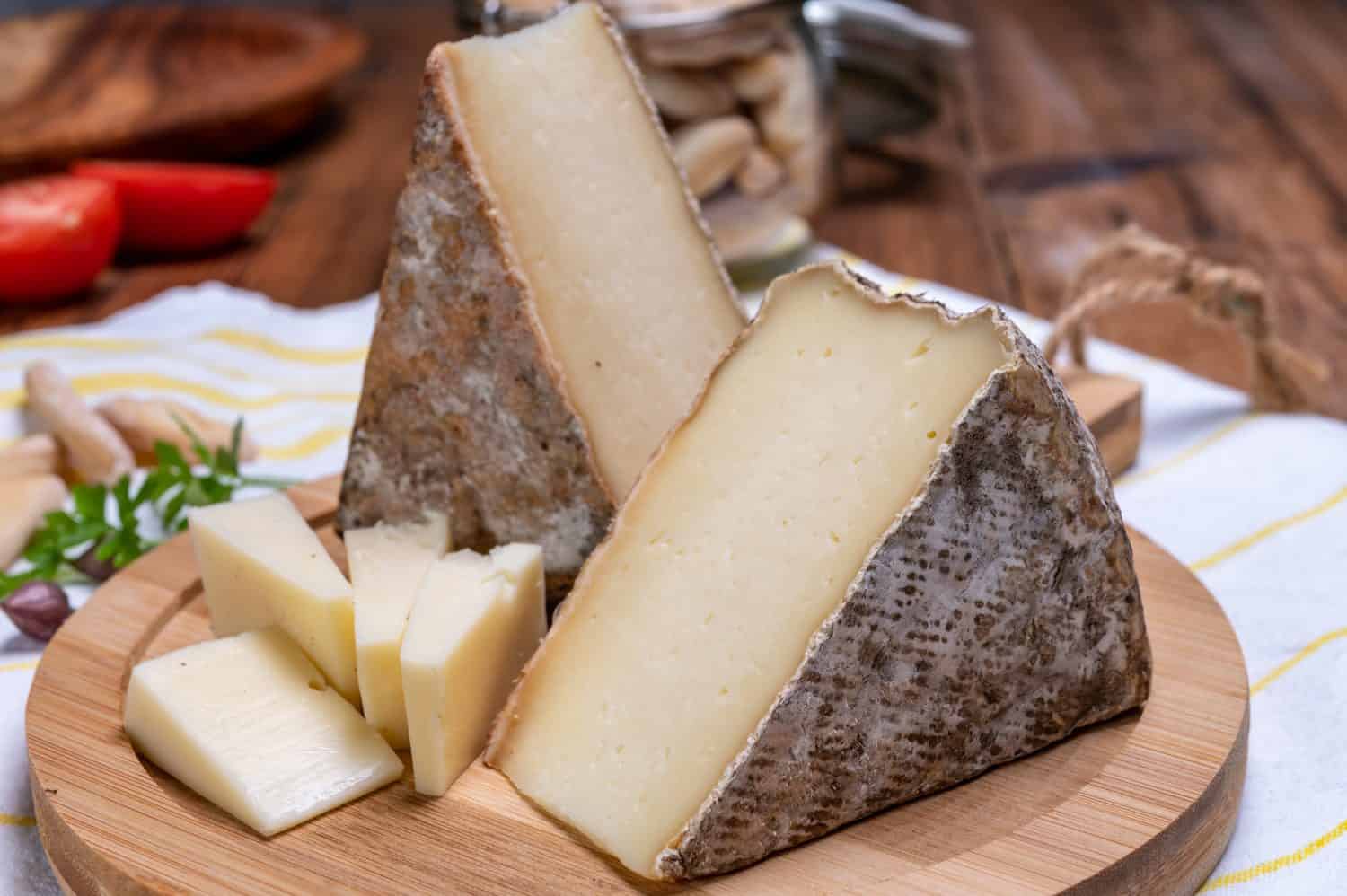 Pieces of cheese tomme de montagne or tomme de savoie made from cow milk in French Alps.