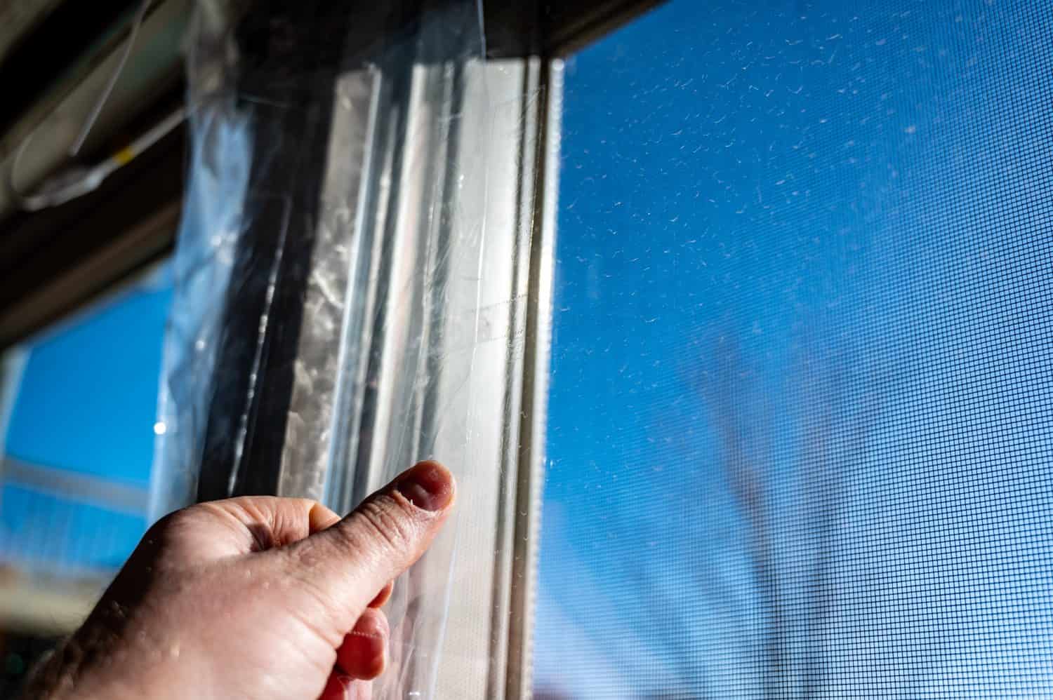 DIY Winterizing a glass door by applying thermal plastic with tape and heat shrinking it