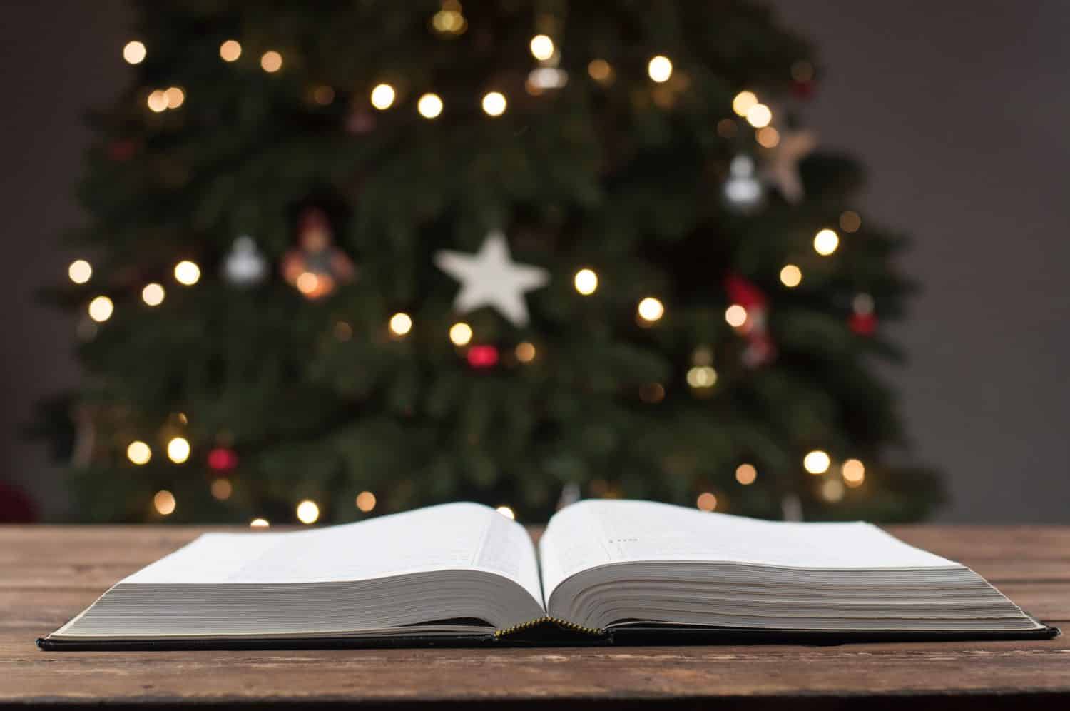 Open book Holy Bible. The Word of God for Christmas. Against the background of the New Year tree