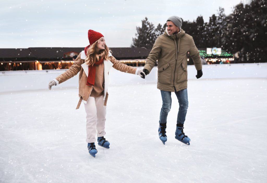 Happy couple skating at outdoor ice rink