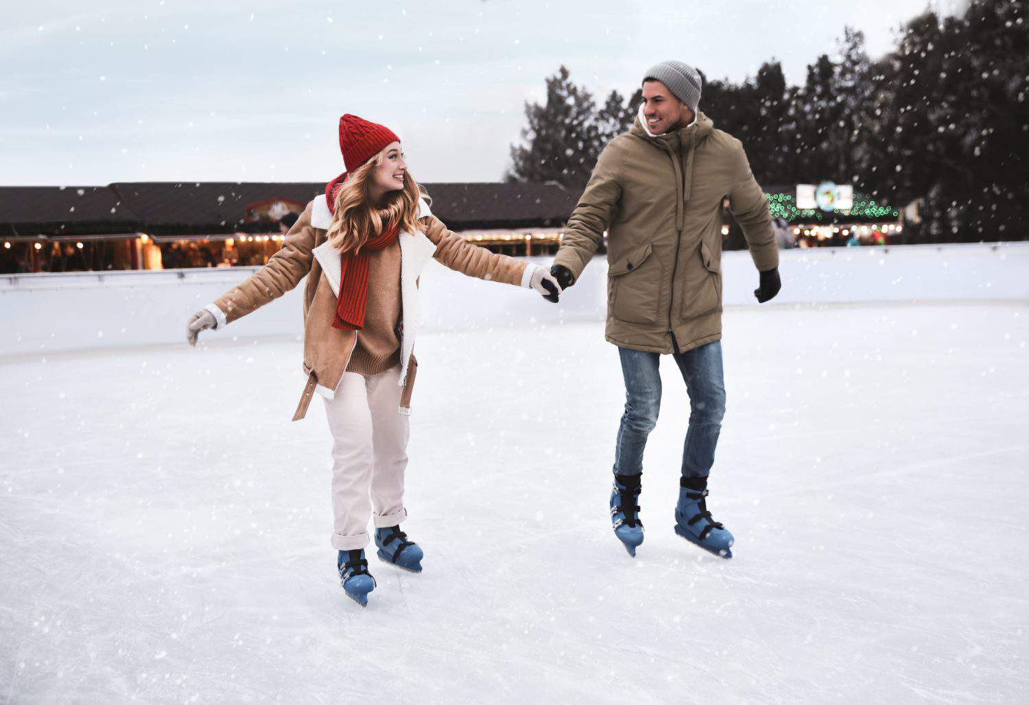 Happy couple skating at outdoor ice rink