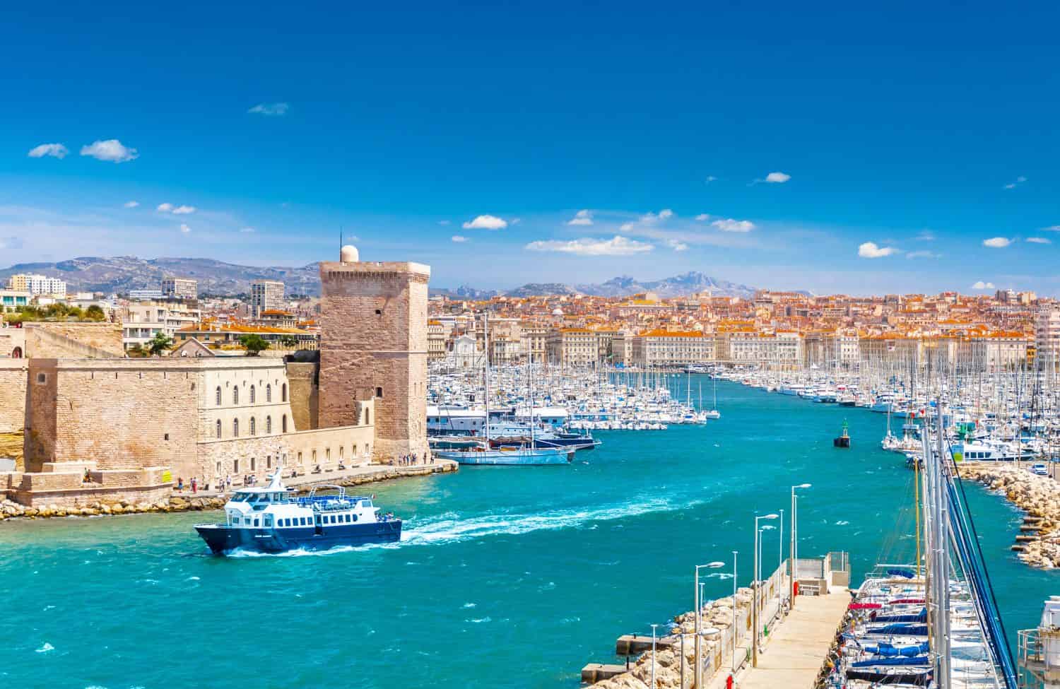 Aerial panoramic view of Marseille Old Port with yachts and boats and the city, mountains in the background. Marseille, Provence, France. Holidays in France