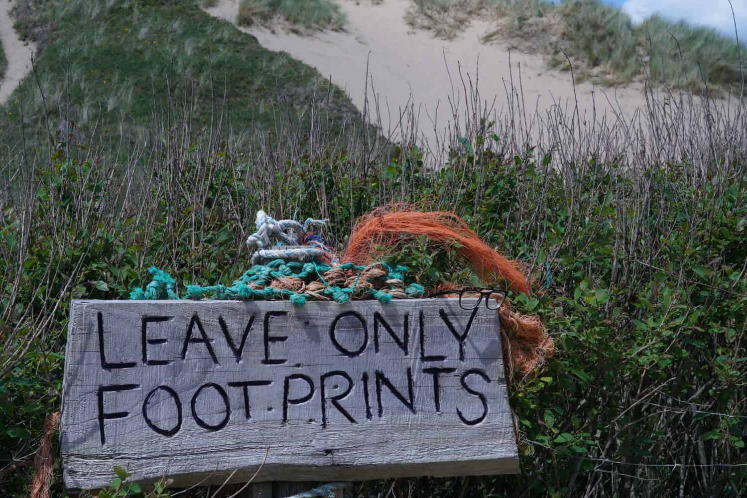 Leave only footprints. Sign left for visitors at Llangennith Beach on the Gower Peninsula reminding them to leave take their litter home and leave no trace of them on the beach. 