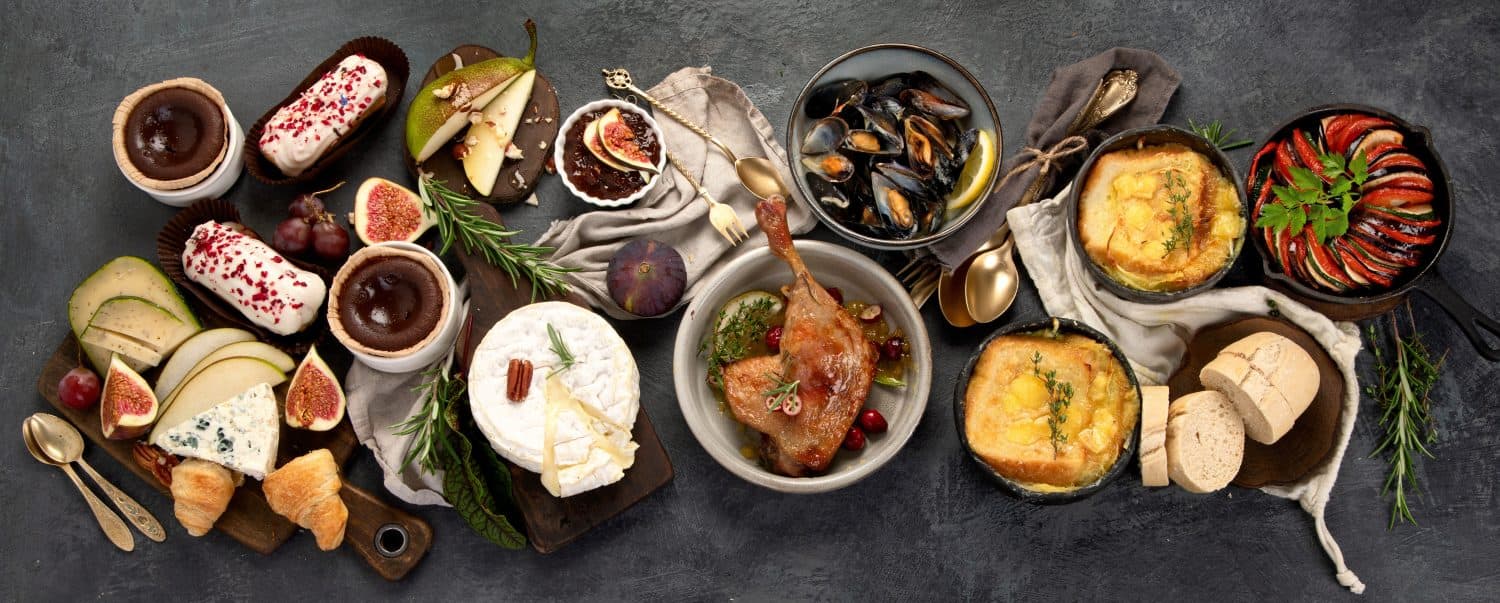 French food assortment on dark background. Traditional cuisine concept. Top view, flat lay, panorama