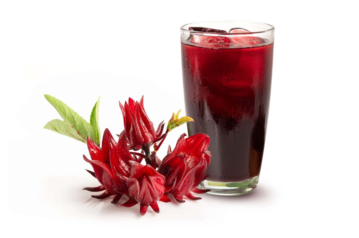 Roselle juice in glass with roselle fruits and leaves isolated on white background.
