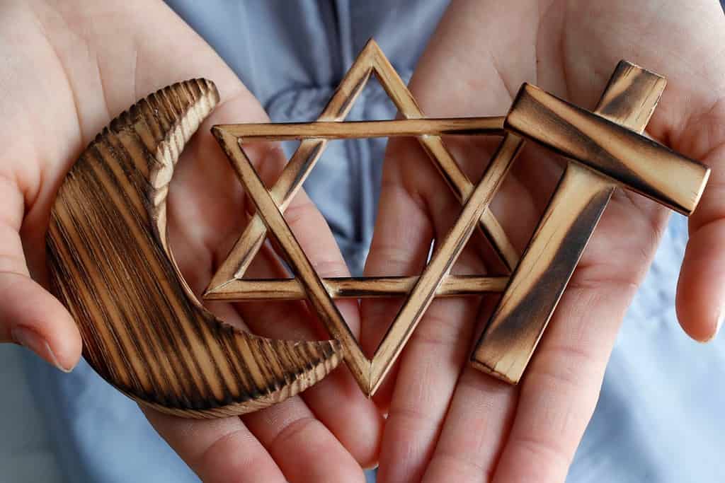 Christianity, Islam, Judaism 3 monotheistic religions. Jewish Star, Cross and Crescent : Interreligious symbols in hands. Religious and faith concept. 06-30-2018