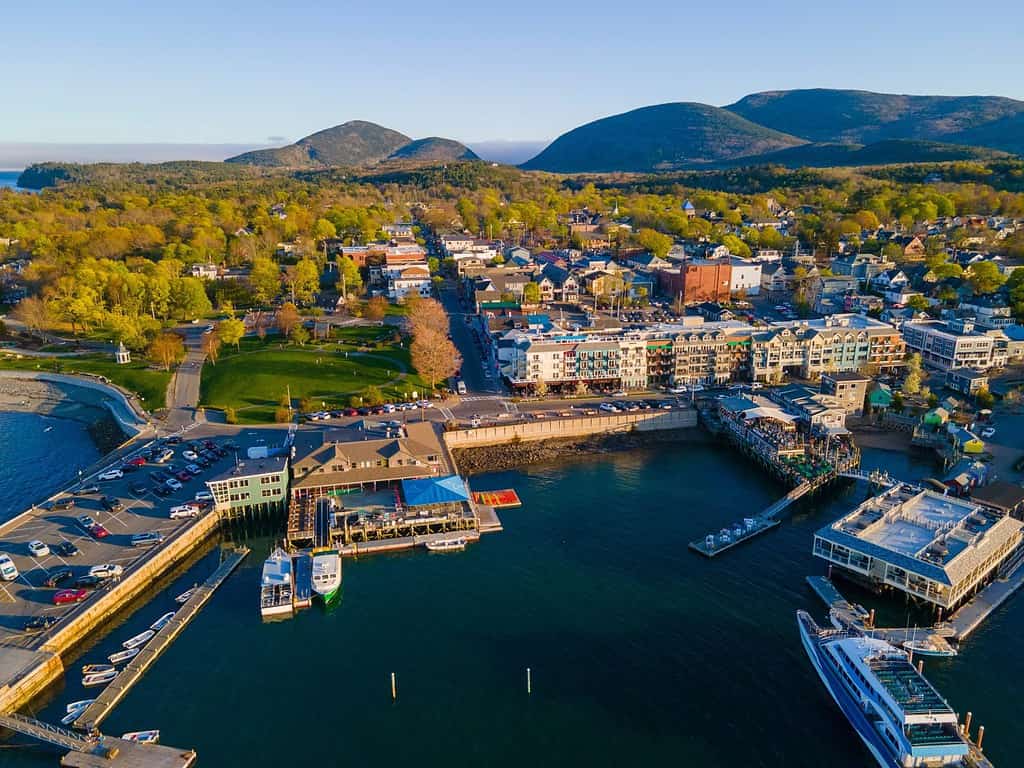 Bar Harbor historic town center aerial view at sunset, with Cadillac Mountain in Acadia National Park at the background, Bar Harbor, Maine ME, USA.