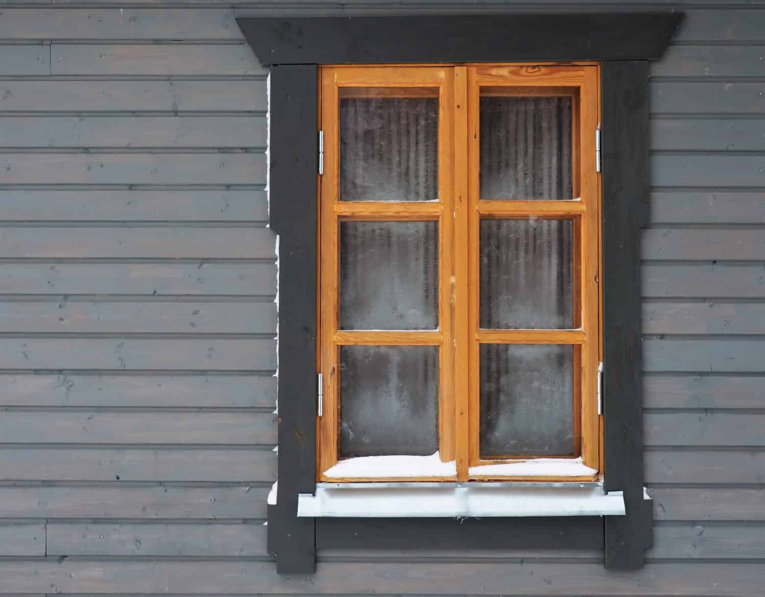 Wooden window of the house in winter. Details of rural buildings. Weather forecast in winter