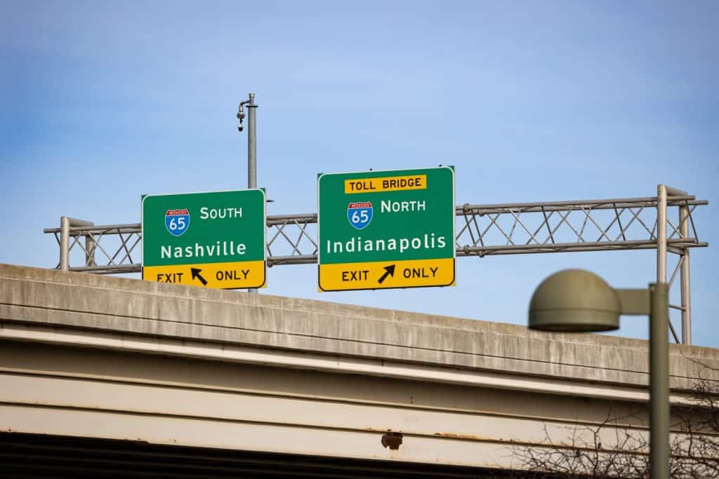 Traffic signs indicating the directions to Nashville and Indianapolis on highway 65, viewed from under a bridge in Louisville, Kentucky.