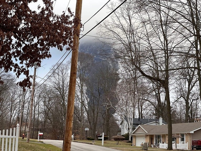 EAST PALESTINE, OH - Circa Feb 2023: The rising smoke cloud after authorities released chemicals from a train derailment as seen from the ground in a nearby neighborhood. Photo credit: RJ Bobin.