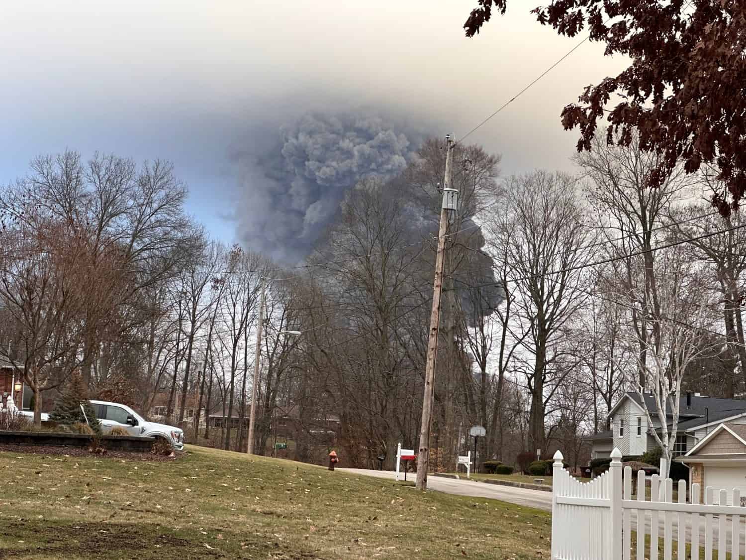 The rising smoke cloud after authorities released chemicals from a train derailment as seen from the ground in a nearby neighborhood. Photo credit: RJ Bobin.