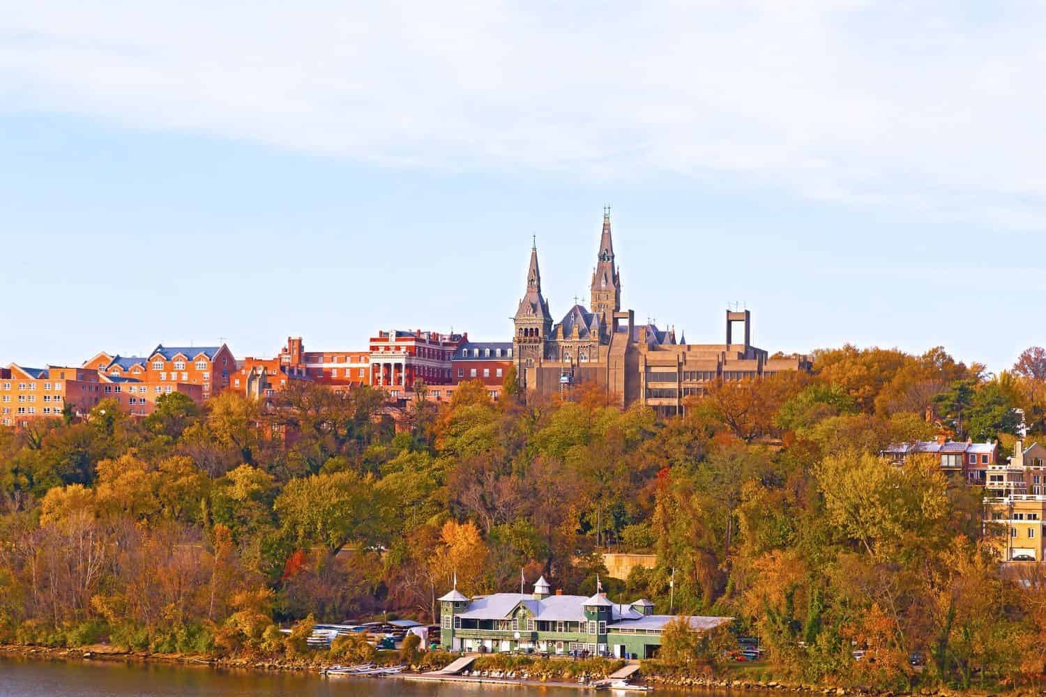 Georgetown University buildings in fall along the Potomac River. Urban scenic panorama in autumn with buildings and recreational facilities.