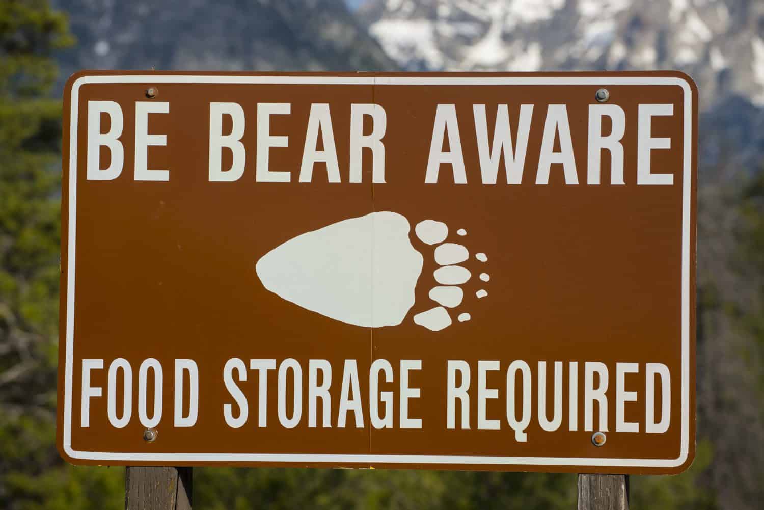 Be Bear Aware warning sign posted in hiking camping area for safety against grizzly attack