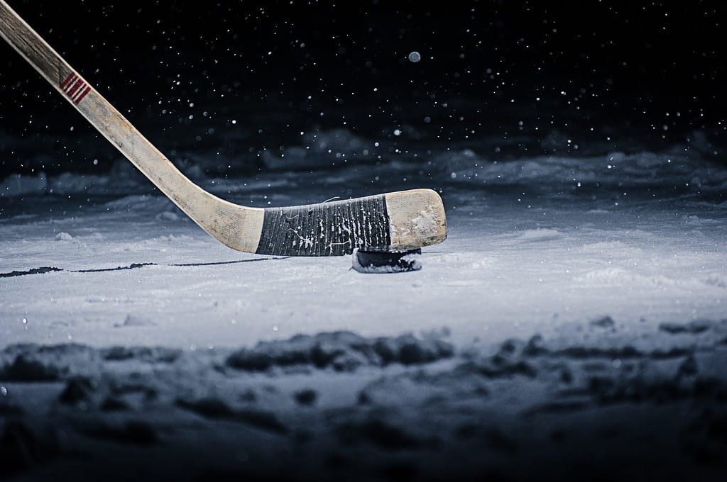 Hockey Stick and Puck on the Ice Rink