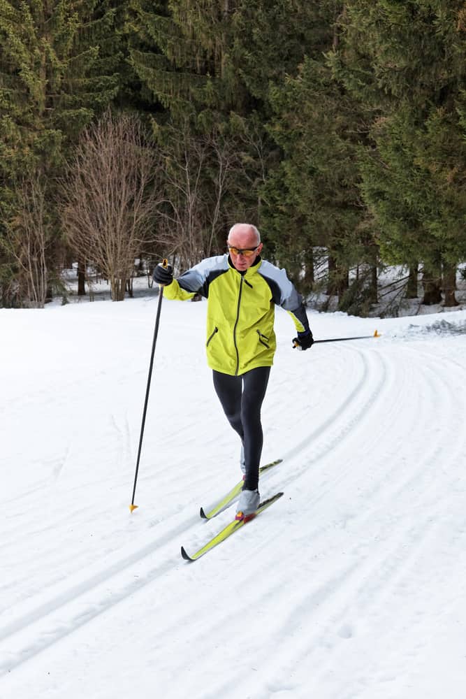 senior in winter on snow to cross country skiing with skis