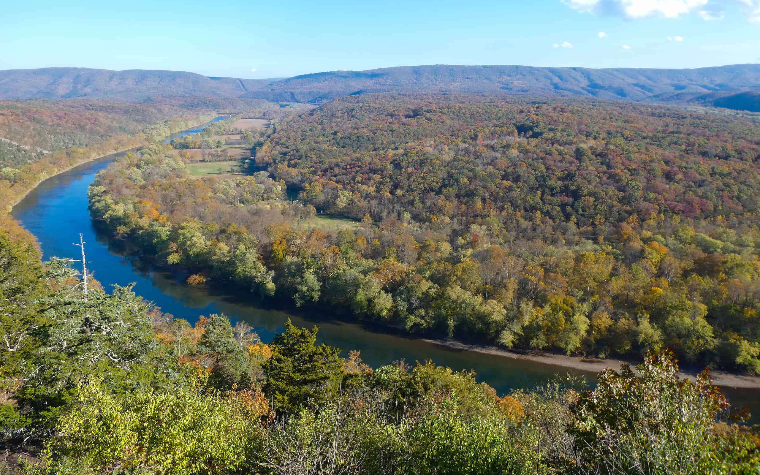 Beautiful view of the Potomac River from Green Ridge State Forest with colorful fall foliage and a clear blue sky on an autumn day.
