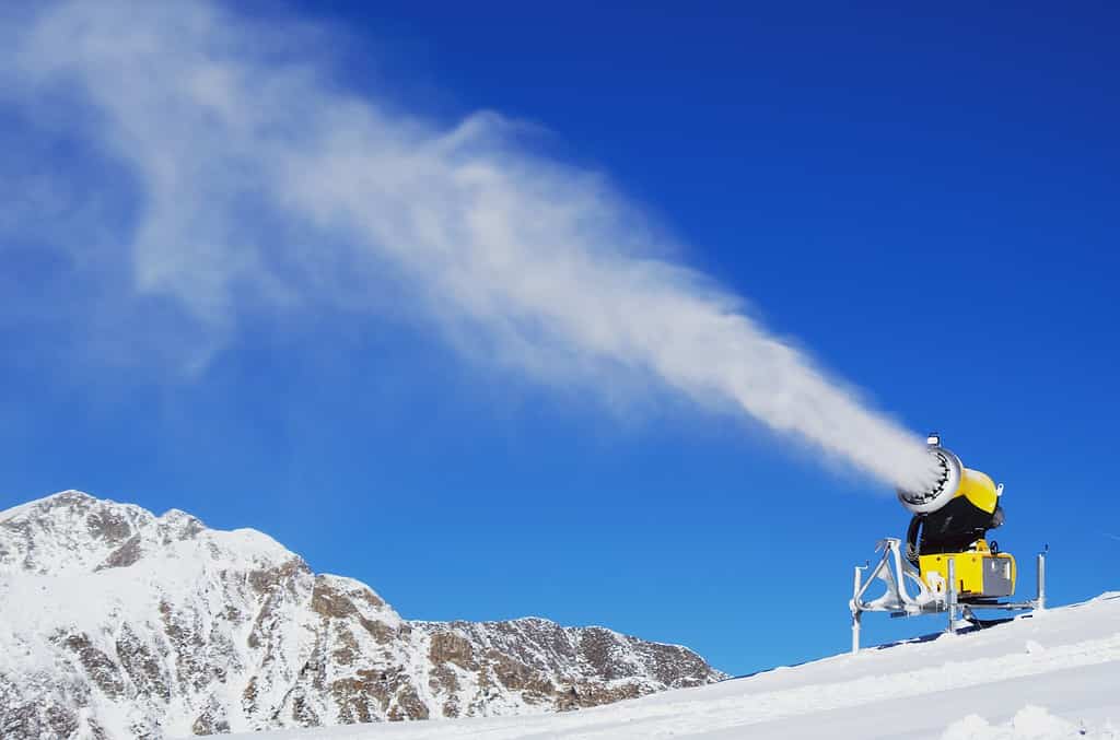 Snow-gun spraying artificial ice crystals. Machine making snow.