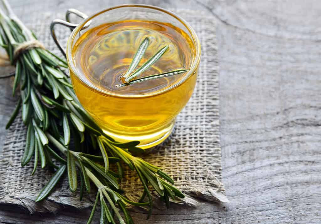 Rosemary herbal tea in a glass cup on rustic wooden background with copy space.Rosemary tea.Selective focus.