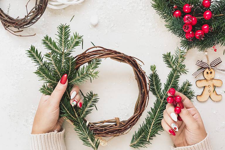 Woman Making A Christmas Grapevine Wreath. Christmas, New Year holiday preparation background