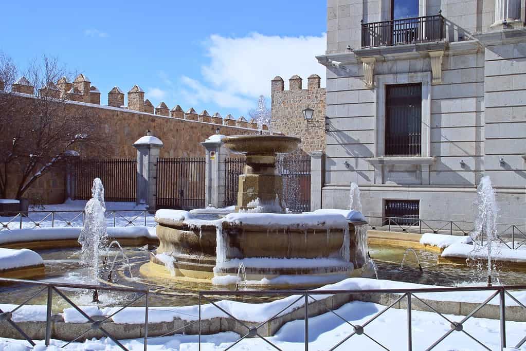 Snowy fountain in the square of Adolfo Suárez in Ávila, Spain.