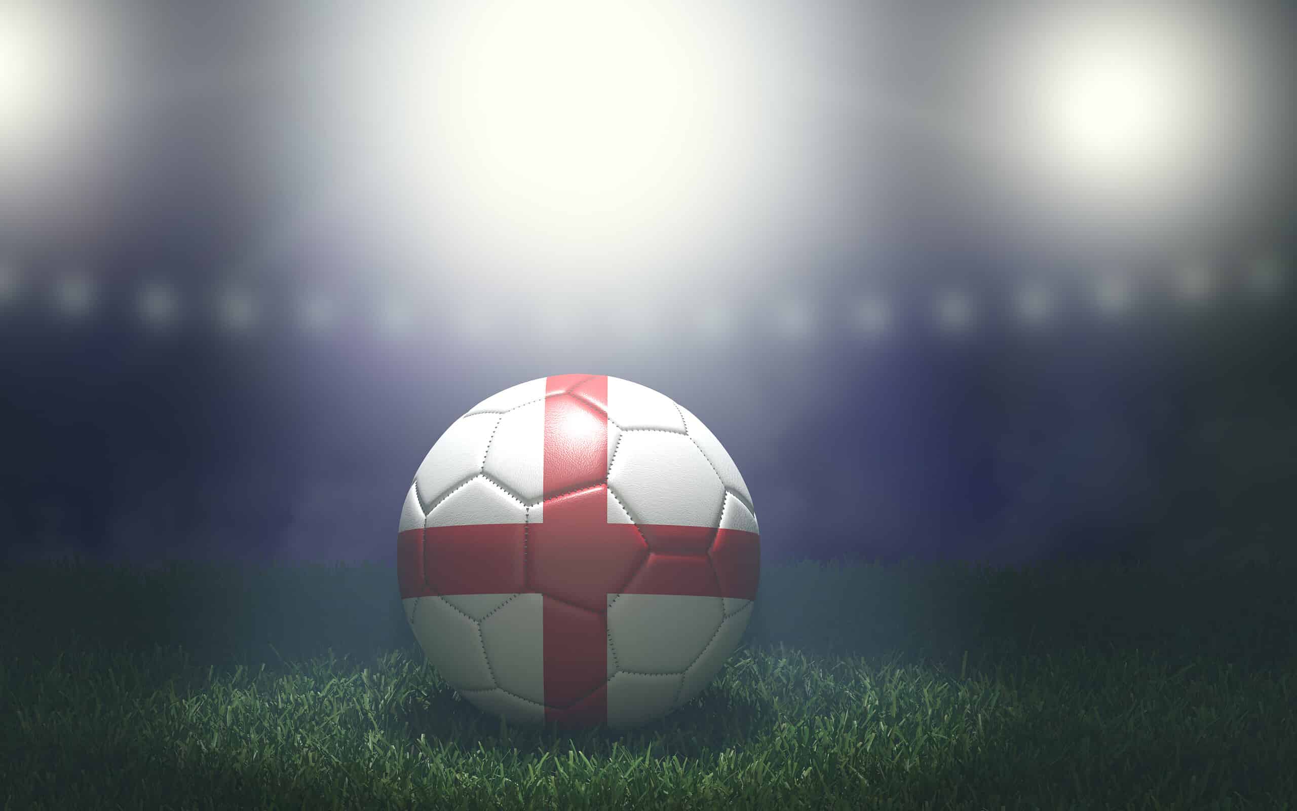 Soccer ball in flag colors on a bright blurred stadium background. England