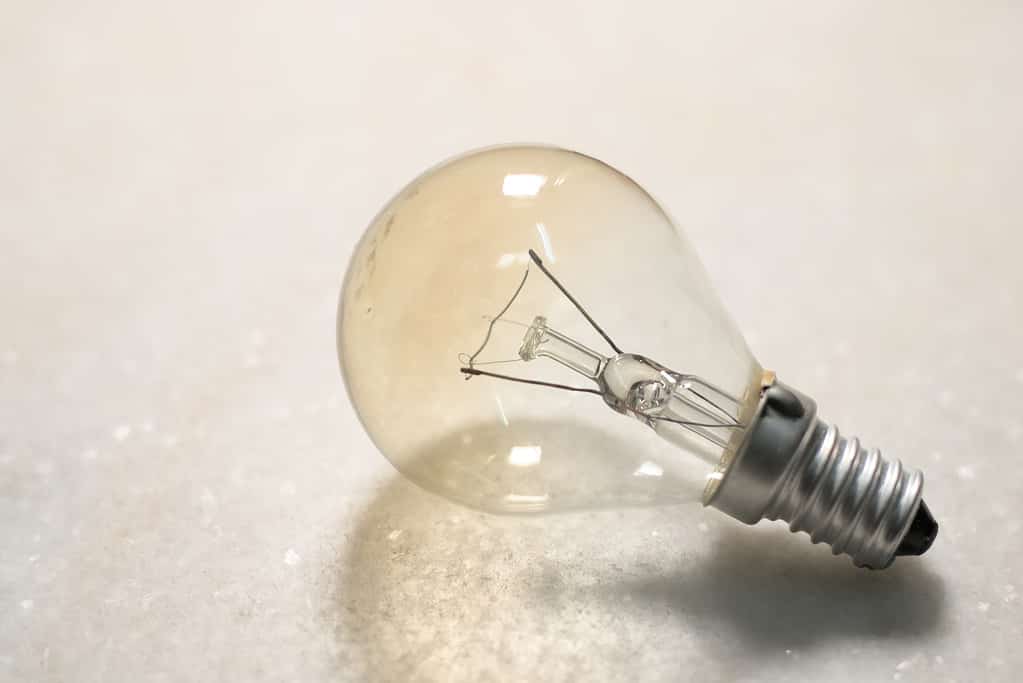 A small incandescent light bulb or lamp on white hard surface