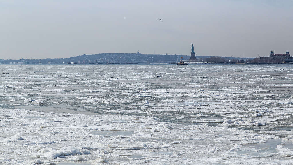 View of the Statue of Liberty across frozen Hudson River