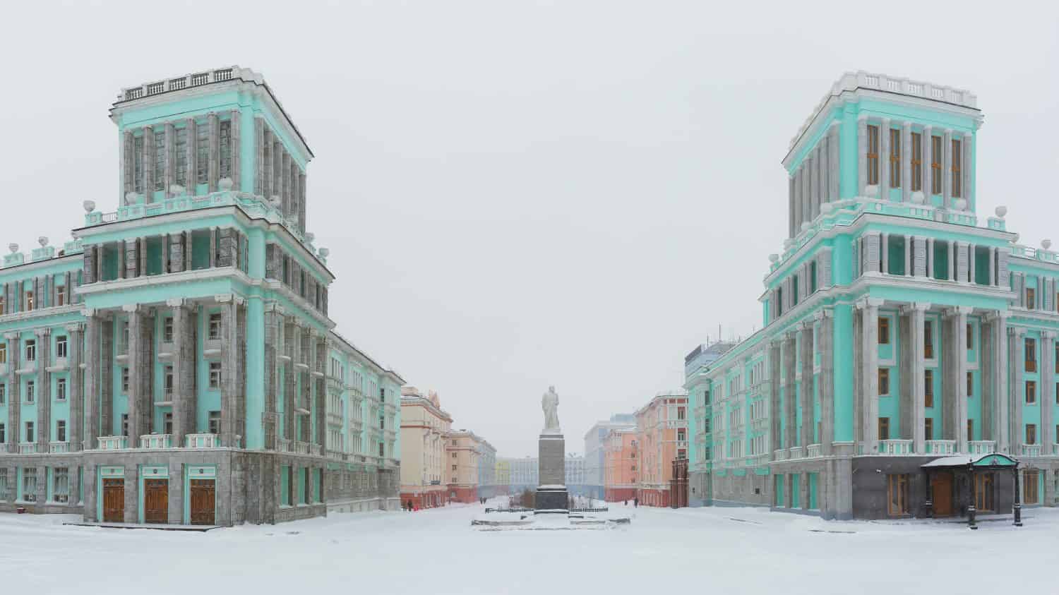 Panorama of October Square in the Norilsk city. Beautiful buildings in the architectural style of the Soviet neo-classicism. In the center is a monument to Vladimir Lenin. Krasnoyarsk region, Russia.