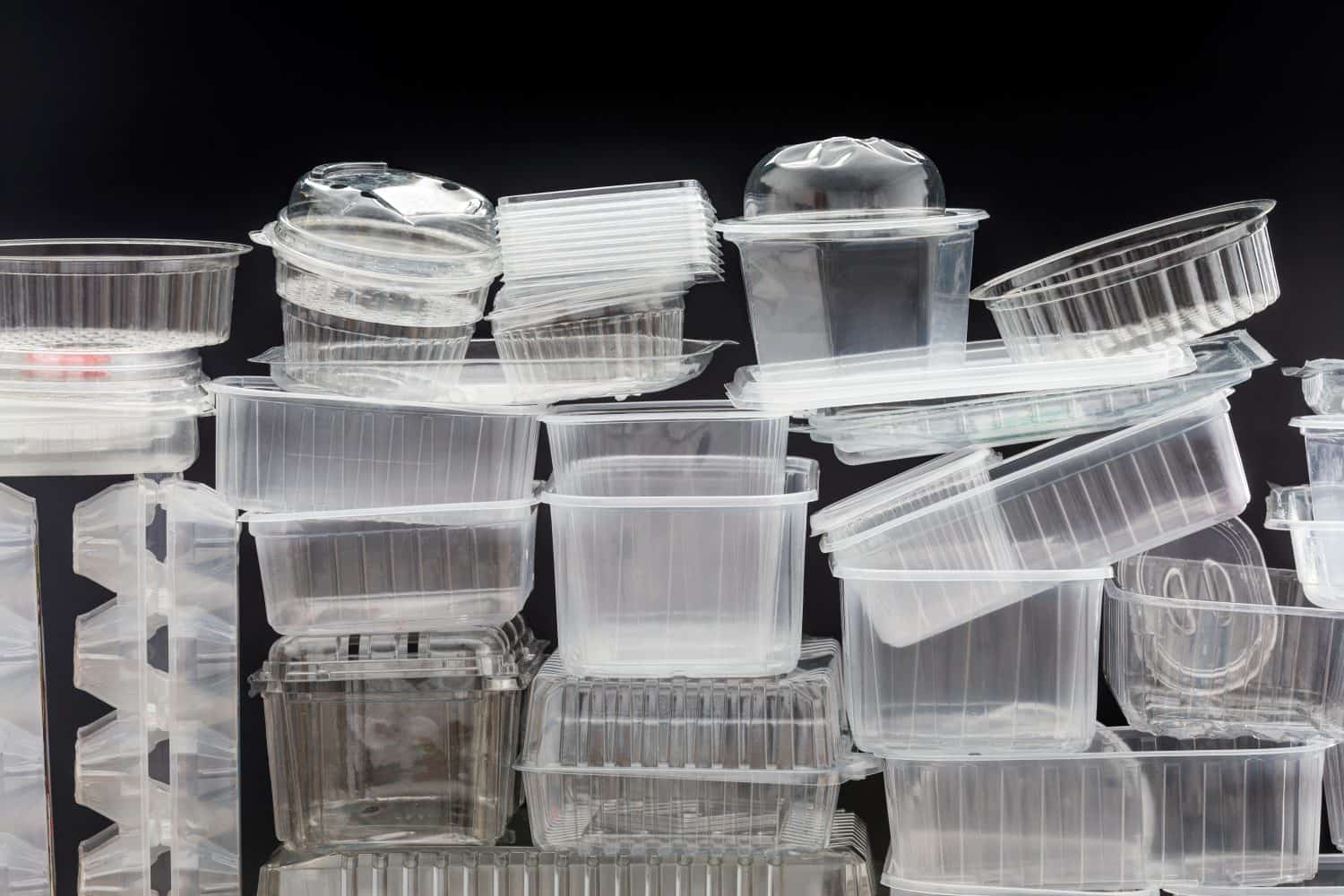 Many clean plastic boxes for food packaging. Pile of disposable plastic containers for take away food.
