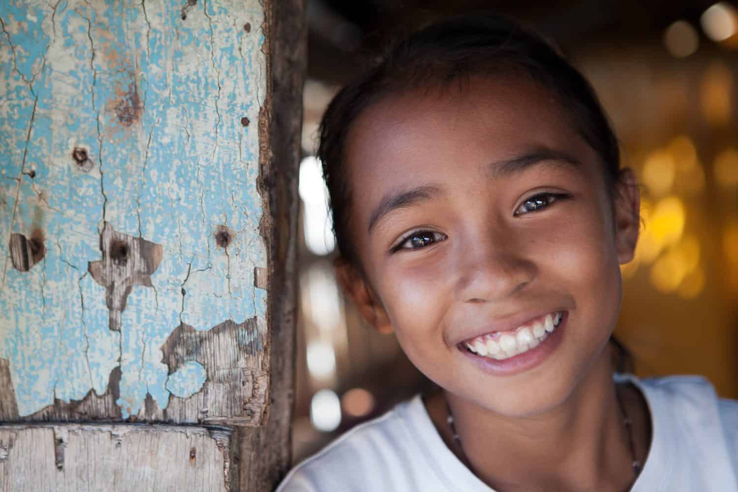 Portrait of a smiling Filipina girl from impoverished neighborhood in the Philippines.