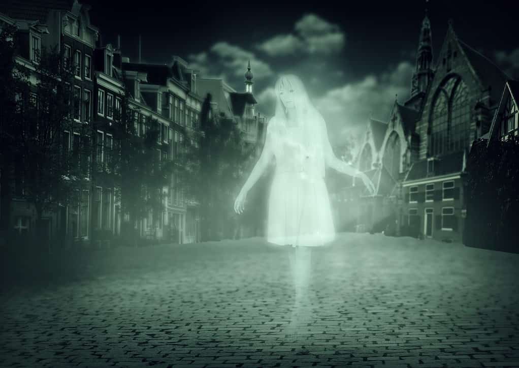 white ghost of a woman walking down the street of the old town