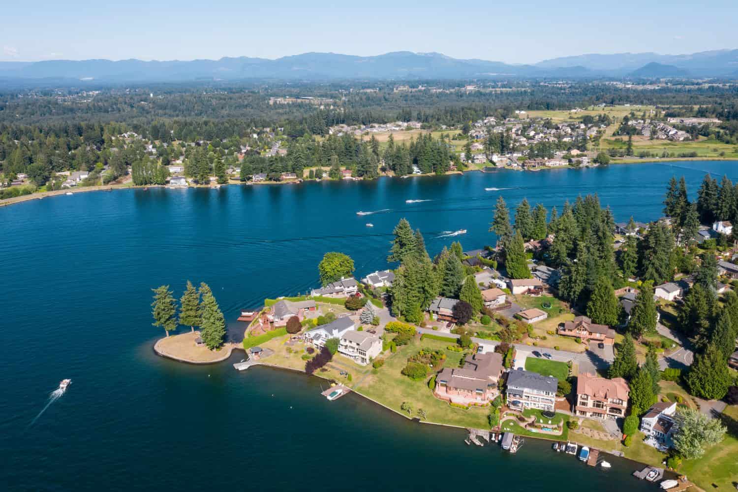USA, Washington State, Lake Tapps. Waterfront homes and boat in lake.