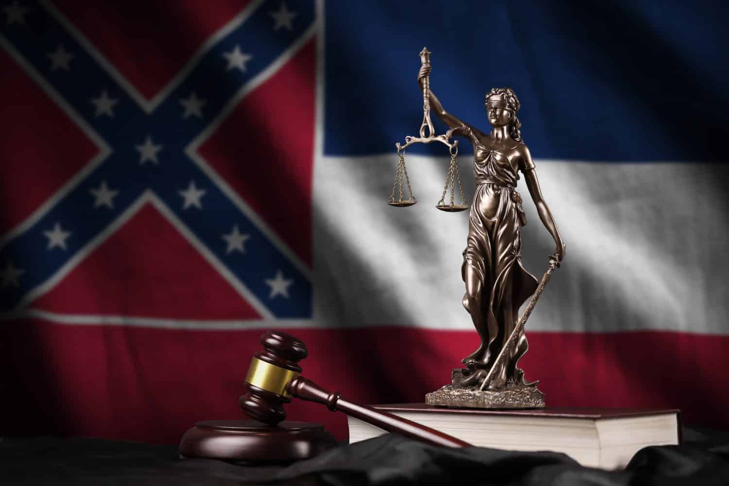 Mississippi new US state flag with statue of lady justice, constitution and judge hammer on black drapery. Concept of judgement and punishment