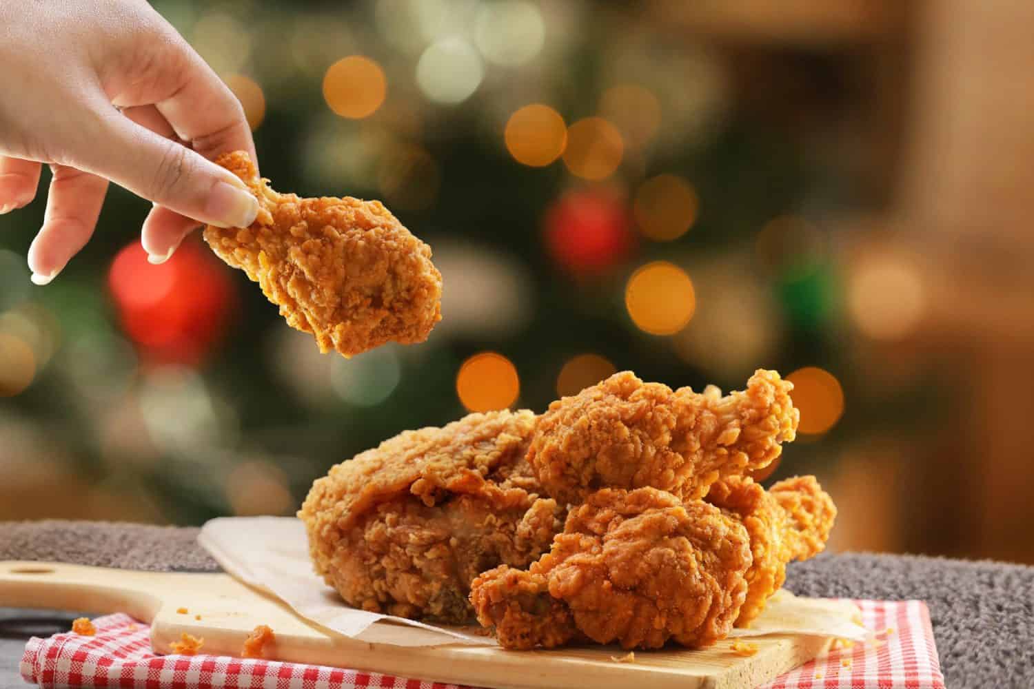Woman hand taking the fried chicken wings by hands,Christmas night dinner.