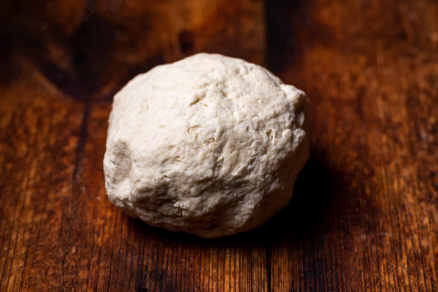 Ball of dough on wooden surface. Preparation of shiver dough for making bread, base for pizza, baguettes