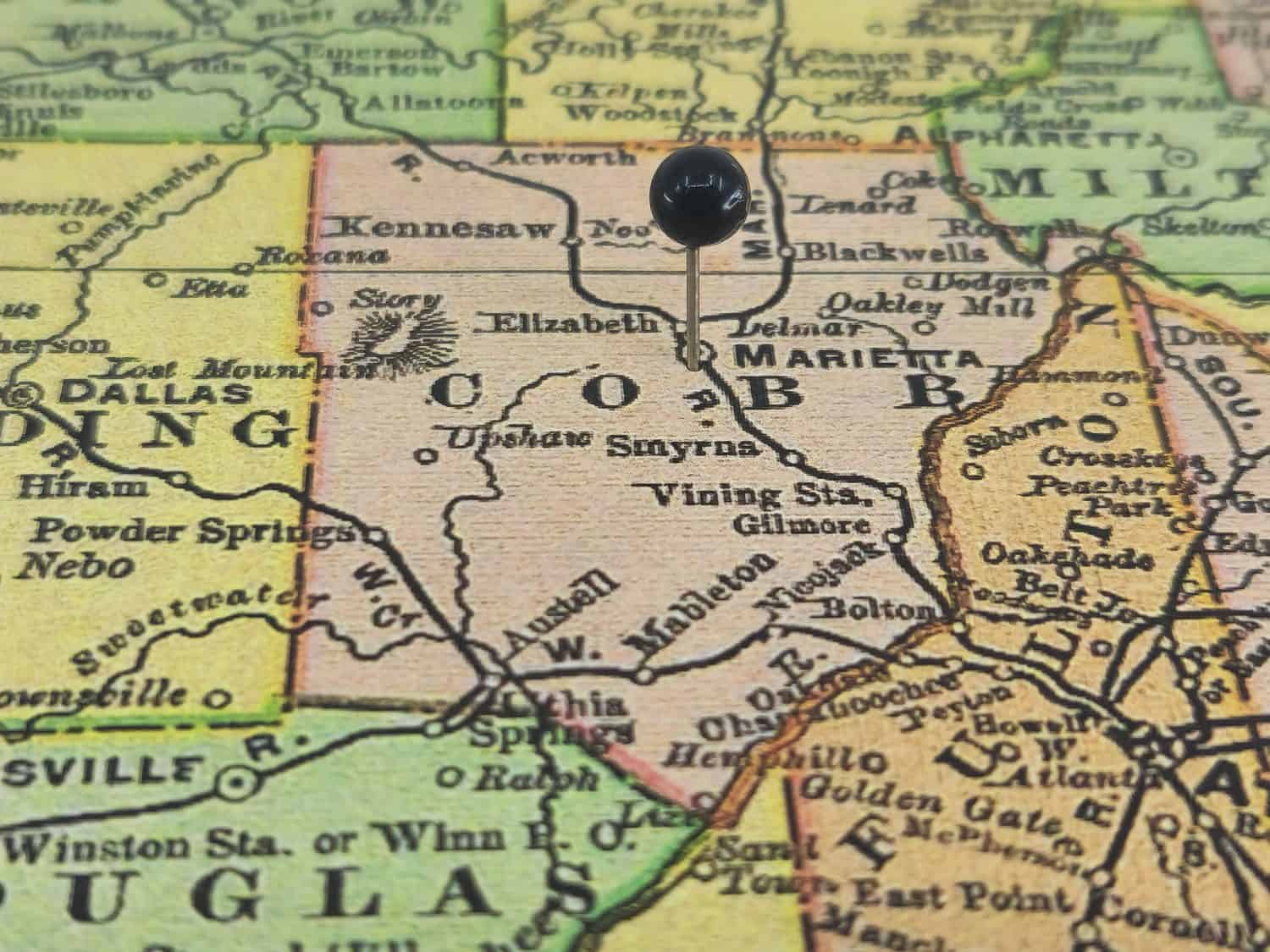 Cobb County, Georgia marked by a black tack on a colorful vintage map. The county seat is located in the city of Marietta, GA.