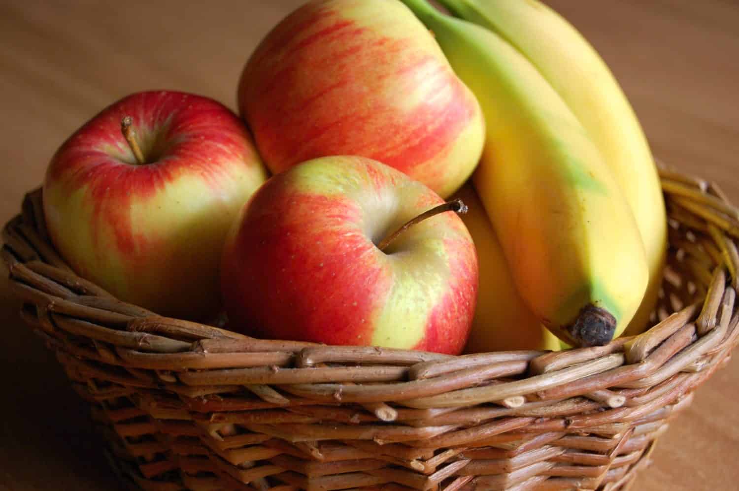 detail of apple and banana in wicker basket