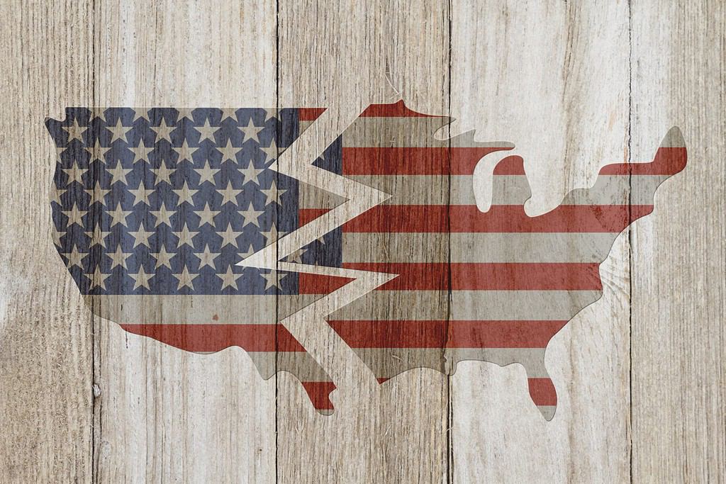 Divided USA patriotic old flag on a map with weathered wood background with copy space for your message