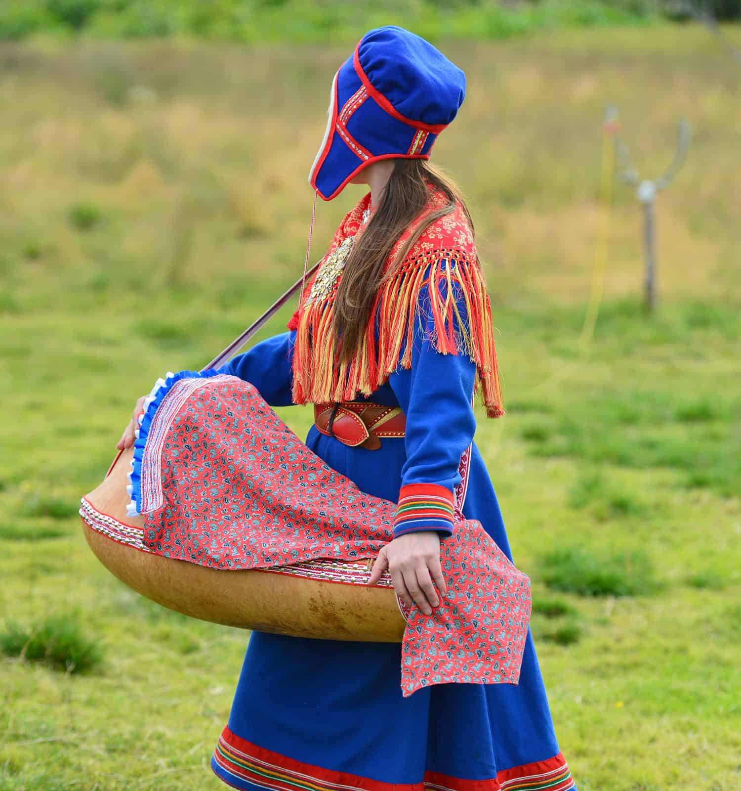 Northern Norway, a traditional dressed Sami woman with a cradle