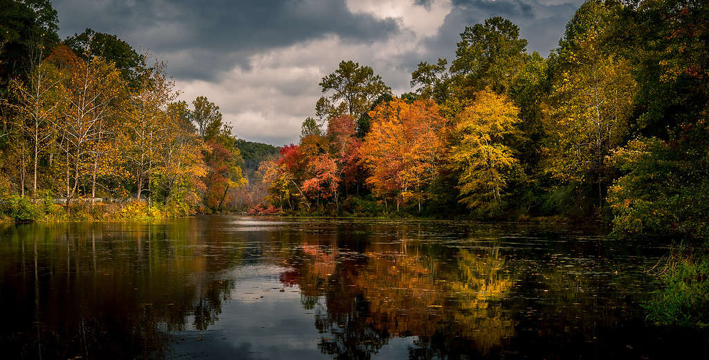 Vibrant autumn foliage reflected in Swartswood Lake at Swartswood Lake State Park, Stillwater, New Jersey