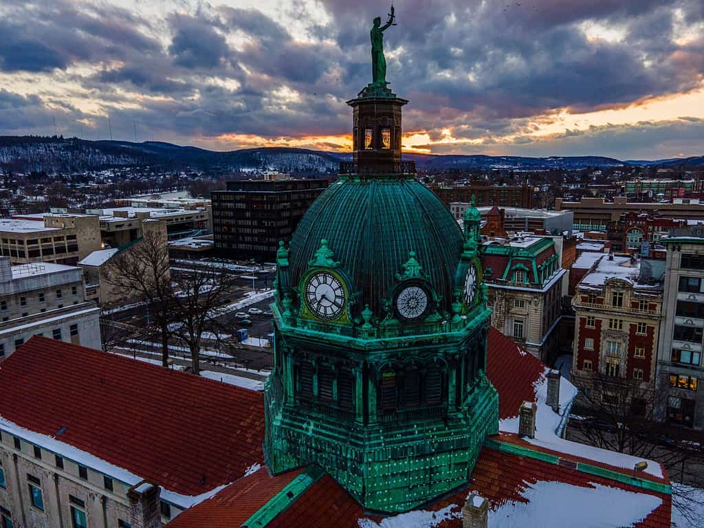 Aerial shot of a green temple in downtown Binghamton, during an orange sunset