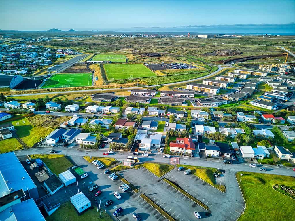 a bird's eye view of a village with fields and mountains: Keflavik